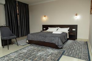 a bedroom with a bed and a chair in it at Таугуль in Zhezdi