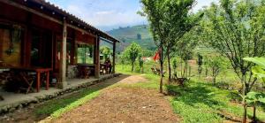 a house with a dirt road next to a field at Luna Valley Homestay in Sapa