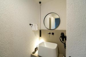 a bathroom with a mirror and a white sink at Alp Suites Mandalin in Akyaka +38 photos