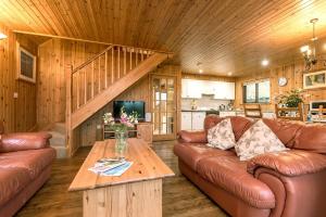 a living room with leather couches and a wooden ceiling at E29 -Lawnside in Truro +7 photos