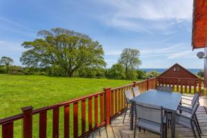 a deck with a table and chairs and a field at E29 -Lawnside in Truro