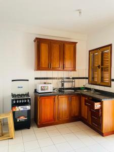 a kitchen with wooden cabinets and a stove top oven at HD Luxury Apparts in Yaoundé