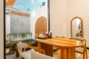 a dining room with a wooden table and chairs at Palm Villa Prawirotaman in Timuran