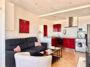 a living room with a black couch and red cabinets at La Caseta - 5907 in Isla