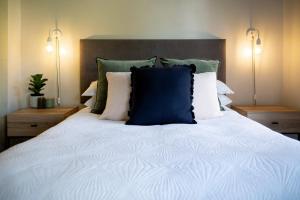 a bed with a blue pillow on top of it at Eunoia Cottage in Paarl