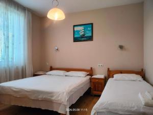 a bedroom with two beds and a window at Guesthouse MIRAJ - SHABLA in Shabla