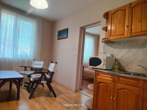 a kitchen with a table and a microwave at Guesthouse MIRAJ - SHABLA in Shabla