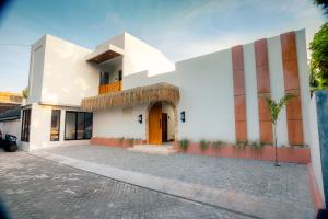 a white building with orange and white stripes at Palm Villa Prawirotaman in Timuran