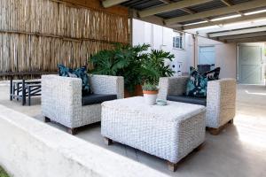 a group of wicker chairs and tables on a patio at Eunoia Cottage in Paarl