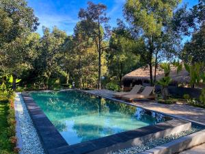 a swimming pool in a yard with a resort at Wimala Farm House in Munduk