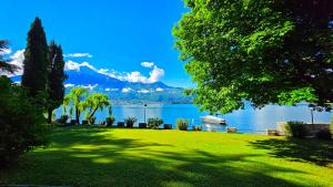 a park with a view of a lake with a boat at Villa Belora in Gera Lario