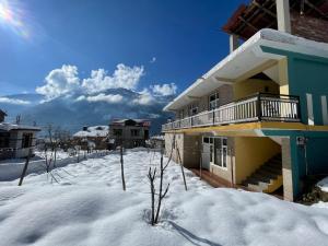 a house in the snow with snow covered ground at Monkeys Junction in Manāli