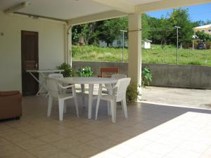 - une table et des chaises blanches sur la terrasse dans l'établissement Cap soleil, à Sainte-Anne