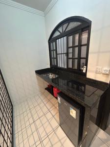 a kitchen with a black counter top in a room at Studio Industrial Moderno in Serra +16 photos