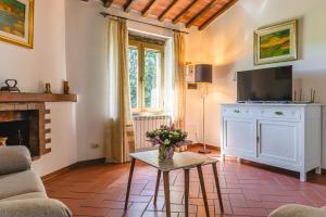 a living room with a fireplace and a tv at Villa Lo Stemma in Monte San Savino
