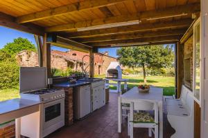 an outdoor kitchen with white appliances and a patio at Villa Lo Stemma in Monte San Savino