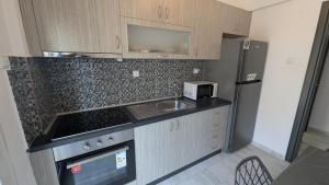 a small kitchen with a sink and a refrigerator at City Flights in Kavála