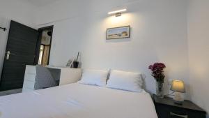 a bedroom with a white bed and a vase with flowers at City Flights in Kavála