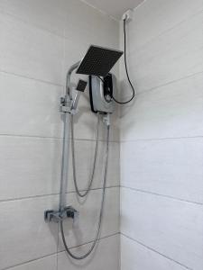 a shower with a laptop on the wall of a bathroom at Ruish City Kandy in Kandy