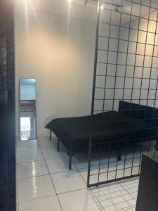 a room with a bed and a mirror at Studio Industrial Moderno in Serra
