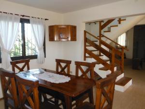 un comedor con una mesa de madera y una escalera en A´mar en Villa General Belgrano