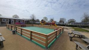 a play court with a playground in a park at Het Strandnest in Renesse