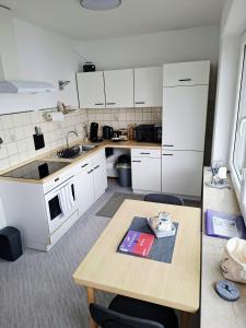 a kitchen with white cabinets and a wooden table at Apartment37671 in Höxter +5 photos