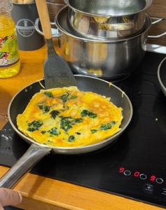 an omelet in a pan on top of a stove at Pastorian Hotel in Maliq