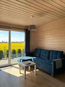 a living room with a blue couch and a table at Szara Gąska w Gąskach in Gąski