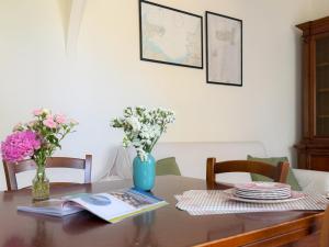 a dining room table with flowers in a blue vase at Casa di Leo - HelloElba in Portoferraio