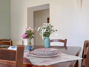 a dining room table with plates and flowers in a blue vase at Casa di Leo - HelloElba in Portoferraio +15 photos