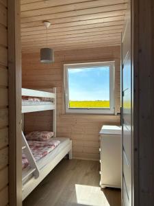 a small room with bunk beds and a window at Szara Gąska w Gąskach in Gąski