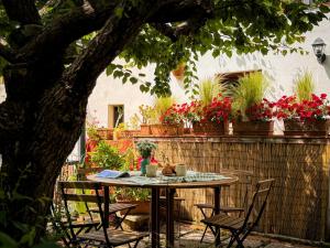a table and chairs in a yard with flowers at Casa di Leo - HelloElba in Portoferraio
