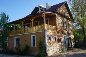 a house with a balcony on top of it at Pastorian Hotel in Maliq
