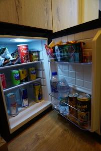 an open refrigerator filled with lots of food and drinks at Pastorian Hotel in Maliq