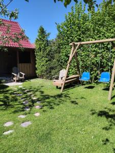 two chairs and a swing in a yard at Domek Karola in Bak
