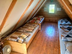 two beds in a room in a log cabin at Domek Karola in Bak