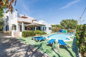 a villa with a swimming pool and blue chairs at Apartamento Felipe 2-2 in Cala d´Or