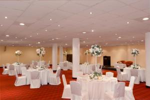 a banquet hall with white tables and chairs and flowers at Al Falaj Hotel - Secure City Escape in Muscat in Muscat +47 photos
