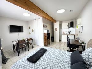a bedroom with a bed and a kitchen with a table at Studios modernes & confort à Valence, Drôme in Valence