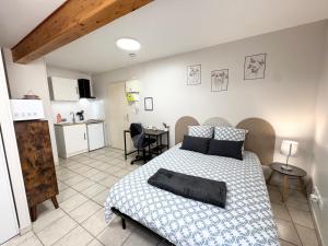 a bedroom with a large bed and a kitchen at Studios modernes & confort à Valence, Drôme in Valence