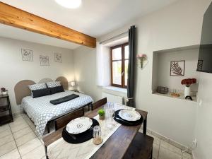 a room with a bed and a table and a dining room at Studios modernes & confort à Valence, Drôme in Valence
