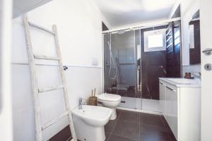 a white bathroom with a toilet and a sink at Aurea Attico con Jacuzzi e vista mare Lignano in Lignano Sabbiadoro