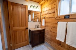 a bathroom with a sink and a wooden wall at Hatcher Pass Cabins in Palmer +19 photos