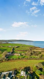an aerial view of a farm with the ocean in the background at No 1 Rhosffordd in Moelfre