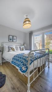 a bedroom with a bed with a blue and white comforter at No 1 Rhosffordd in Moelfre