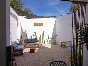 a patio with two chairs and a cactus wall at META Affittacamere in Càbras