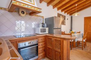 a kitchen with a stove and a microwave at Es Coll d'en Pastor in Fornalutx