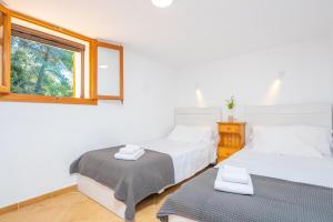 two beds in a room with a window at Es Coll d'en Pastor in Fornalutx
