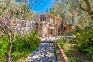 an exterior view of a stone house with trees at Es Coll d'en Pastor in Fornalutx